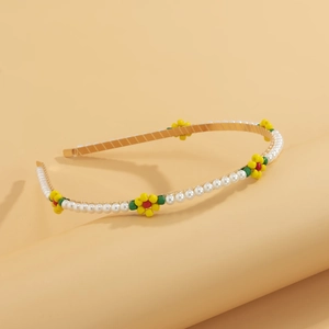 Detail view of gold headband with faux pearls and colorful beaded daisy flowers