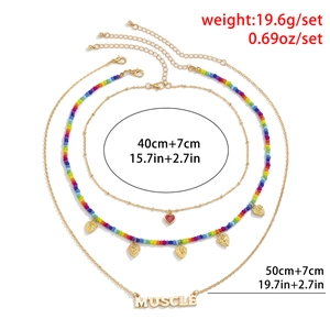 Driedelige gelaagde gouden kettingset met regenboogkralen, hartjes en MUSCLE-hanger