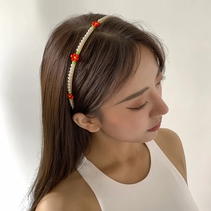 Chic gold headband with white faux pearls and colorful beaded daisy flowers on a model