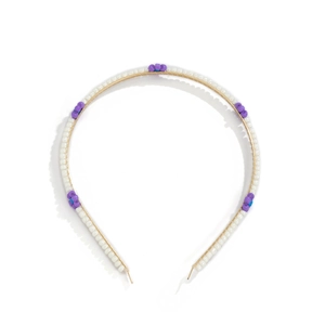 Detail of handmade white beads and purple flower accents on a gold-tone headband