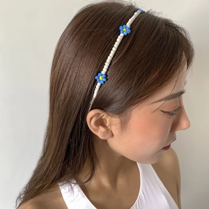 Boho hand-beaded daisy headband with blue and yellow flower charms on white beads