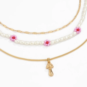 Detailopname van drielaagse ketting met parelbloemen en een schattige paddenstoel hanger