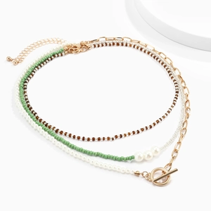 Detail van gelaagde kralenketting met gouden OT-sluiting en verlengketting