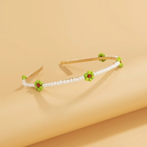 Close-up of beaded daisy headband with gold frame and white pearls in pastoral style