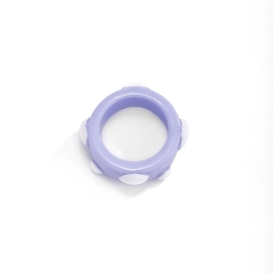 Detail eines hellvioletten Harzrings mit weißen Noppen und glatter Oberfläche im Retro-Stil