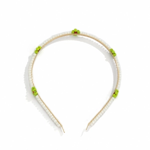 Detail view of woven beaded headband featuring red and green daisy patterns on white pearls