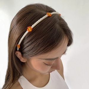 Detail of beaded floral headband with white pearls and colorful flower accents