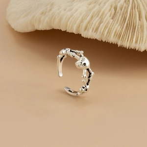 Gothic punk open teenring met gekruiste schedels op wit koraal decoratieve basis
