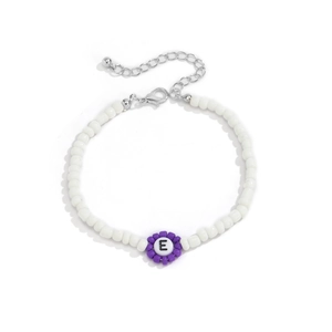 Detalle del collar de cuentas blancas con una flor púrpura y un colgante con la letra E