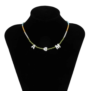 Detail van handgemaakte kralenketting met kleurrijke kralen en A-M hartjes hangers