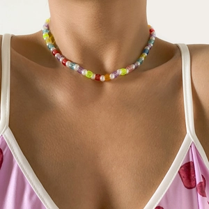 Colorful beaded necklace with white pearls and translucent beads on a female model