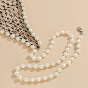 Detail of faux pearl body chain with black fishnet mesh and sparkling rhinestone accents