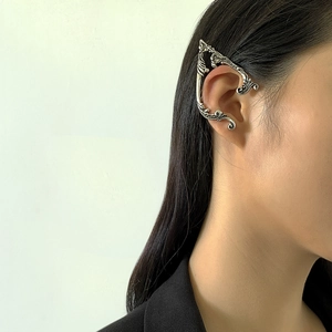 Detailed view of silver gothic elf ear cuff with vintage filigree floral carvings