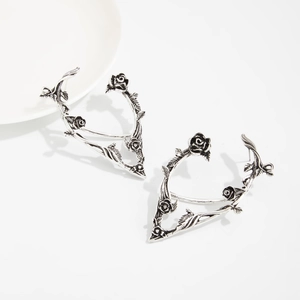 Detailed macro view of retro silver elf ear cuff with black roses and vine leaves