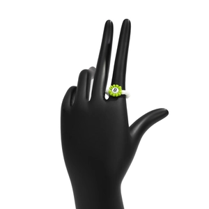 Primer plano de anillo de cuentas hecho a mano con flor verde y letra B sobre soporte negro