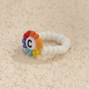 Detalle de anillo de cuentas hecho a mano con una letra C de colores estilo bohemio