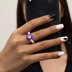 Anillo de cuentas hecho a mano con flor púrpura y detalle de letra m en el dedo
