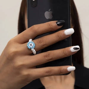 Primer plano de un anillo de cuentas azules y blancas con detalle de la letra H negra