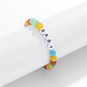Dettaglio di perline occhio di gatto colorate e lettere BABY in acrilico su bracciale