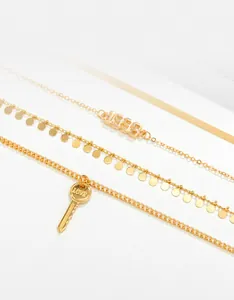 Detalle de collares dorados con colgante 1998, lentejuelas y dije de llave love