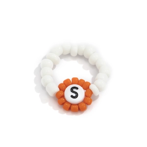 Detalle de un anillo de cuentas hecho a mano con perlas blancas y flor naranja con letra S