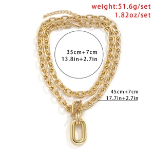 Detail of gold multilayer aluminum chain necklace featuring OT clasp and oval pendant