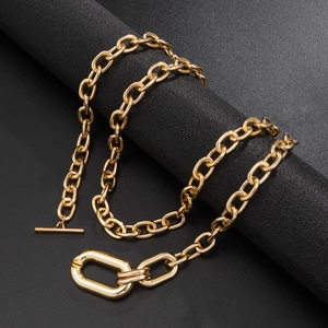 Golden chunky chain necklace with OT toggle clasp and oval rings on black background