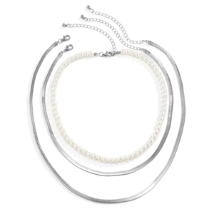 Detalle de collar multicapa con cadenas de serpiente plateadas, perlas y cierre de langosta