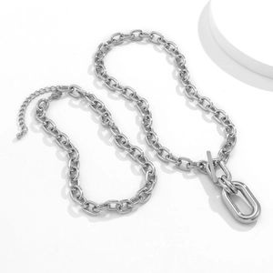 Close-up of chunky silver chain necklace featuring a toggle clasp and oval ring pendant