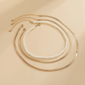 Detalle del conjunto de collares de cadenas de serpiente doradas y perlas con cierres