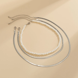 Detalle del juego de 3 collares con perlas blancas y cadenas de espiga plateadas