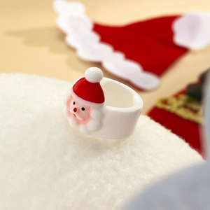 Dettaglio anello natalizio in acrilico con Babbo Natale 3D su superficie morbida