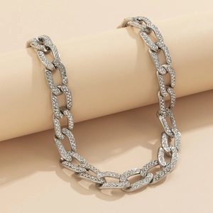 Close-up van zilveren Cubaanse schakelketting met micro-pave strass op beige display
