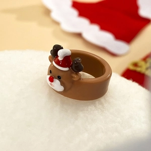 Dettaglio di un anello in acrilico con renna e cappello di Babbo Natale su neve