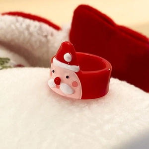 Dettaglio di un anello natalizio con Babbo Natale in acrilico su sfondo bianco neve