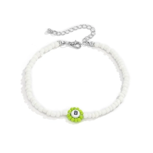 Detalle de collar de cuentas blancas con flor verde y cuenta de letra B sobre fondo blanco