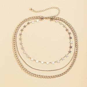 Detalle de un collar plateado de tres capas con colgantes de estrellas y eslabones punk