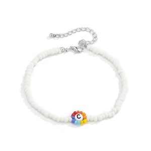 Detalle de collar de cuentas blancas con toques coloridos y dije con la letra C