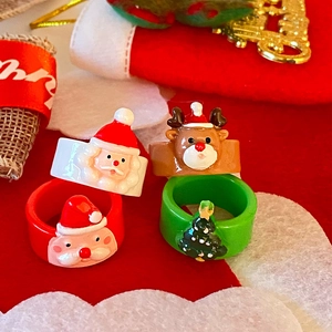Anelli natalizi in acrilico colorato con Babbo Natale e renne su sfondo rosso festivo