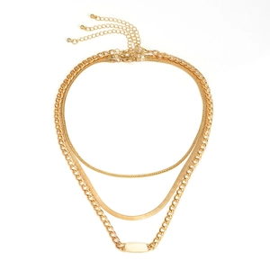 Detalle de collar triple dorado con eslabones de tipo bordillo, serpiente y clásicos