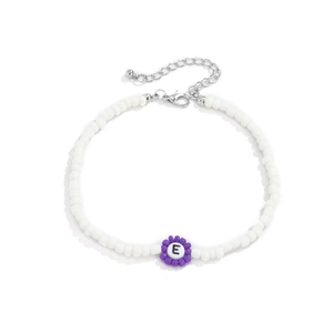 Detalle de collar de cuentas blancas con flor morada y cuenta con la letra E