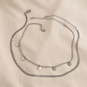 Detalle de collar de doble capa plateado con colgantes Love y cadena de serpiente
