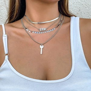 Collar de capas plateado con colgante de llave Love y número 1998 puesto en modelo