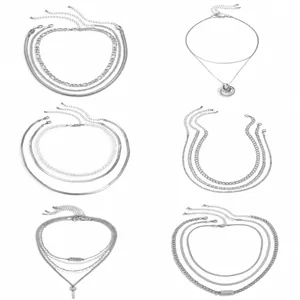 Juego de collares plateados de varias capas con colgantes geométricos y perlas detalladas