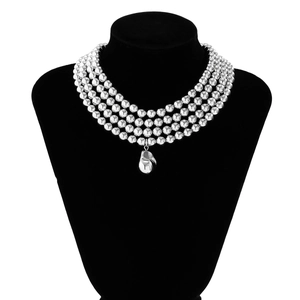 Close-up of four-layer silver bead chain with irregular metal pendant on a black mannequin