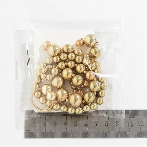 Detail of layered gold metal beads in various sizes on a hip-hop style necklace