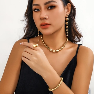 Close-up of layered golden bead jewelry set featuring necklace and drop earrings