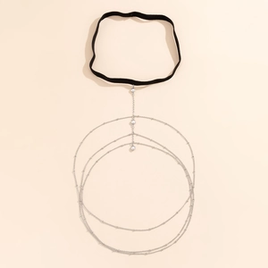 Detail of layered silver thigh chain with pearl beads and black elastic garter band
