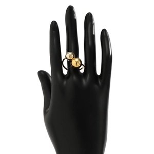 Detail view of bold gold polished metal double bead ring on a mannequin hand