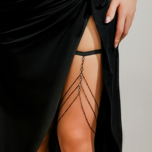Macro shot of black thigh chain with layered metal tassels and sparkling rhinestones